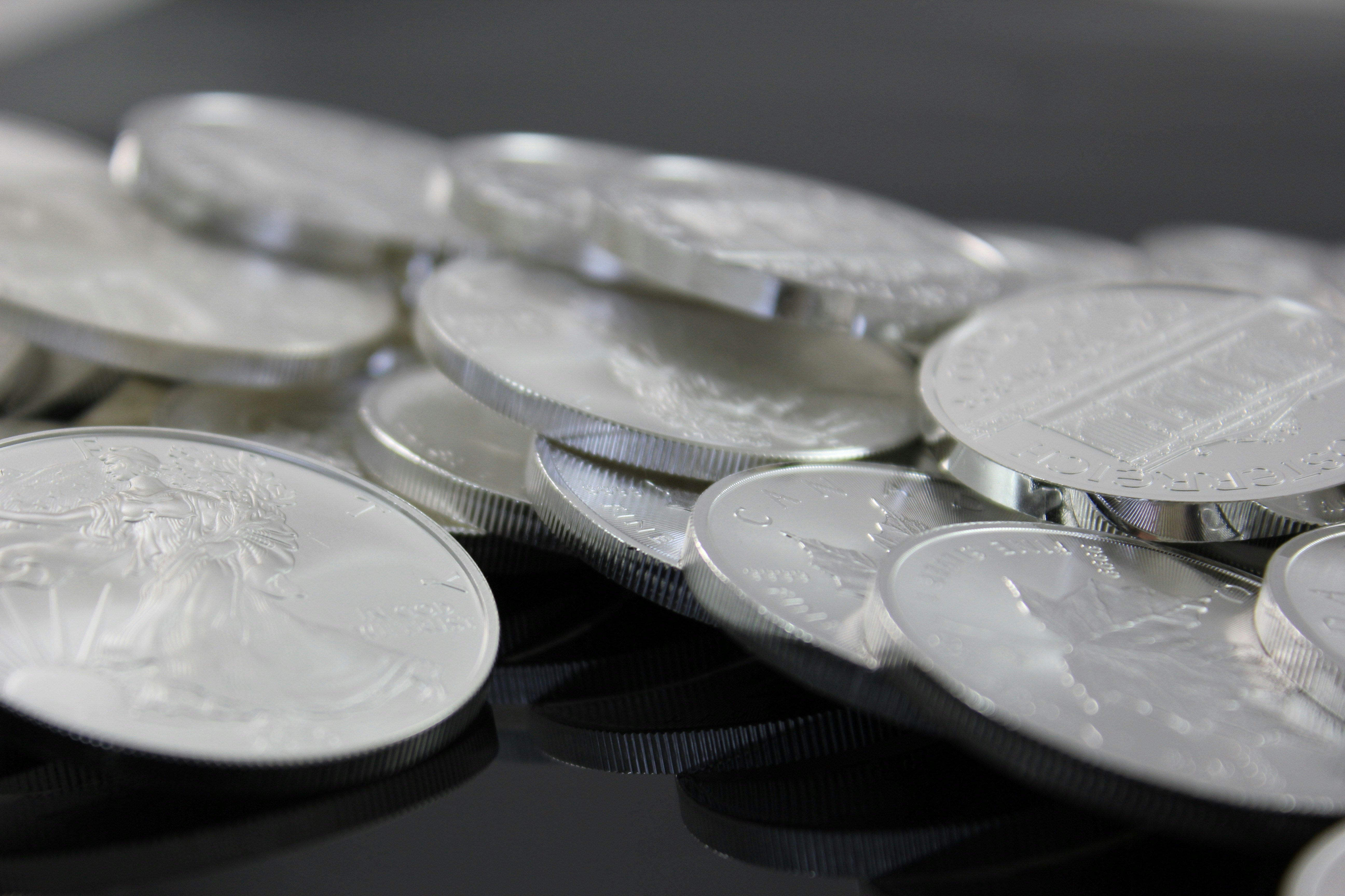Silver bullion coins on a reflective surface
